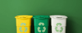 3 recycling containers against a green wall