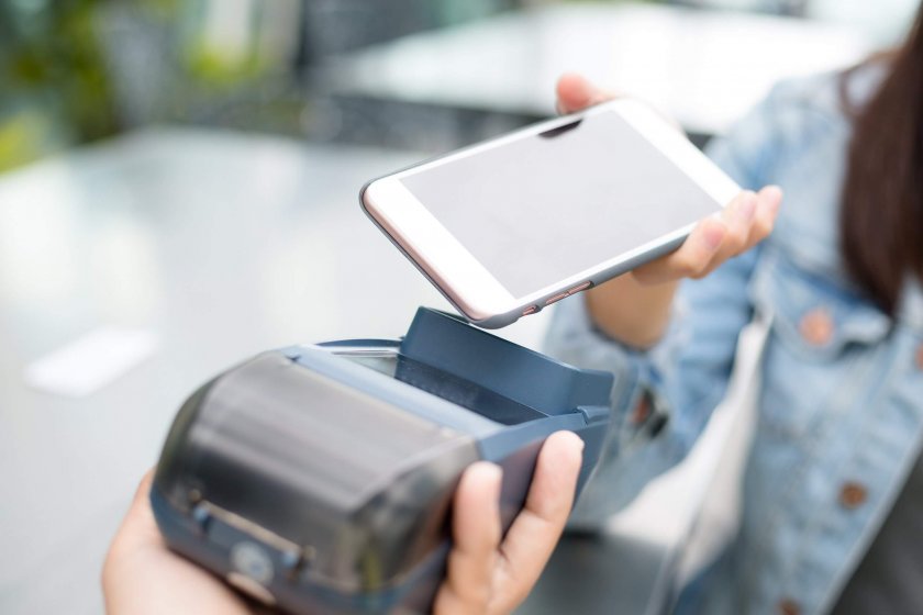 Woman using cellphone to pay with NFC technology